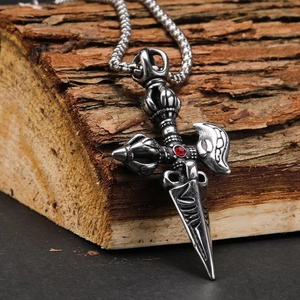 Macro detail of retro punk cross pendant with red gemstone on textured wood