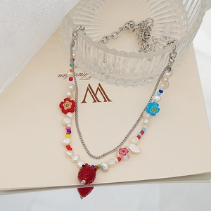Détail du collier multicouche avec perles d'eau douce et pendentif fraise en verre rouge