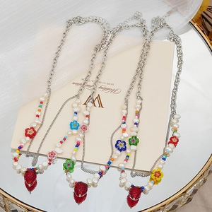 Collier en perles d'eau douce avec fraise en résine et breloques de fleurs colorées