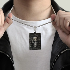 Gros plan du collier dog tag crâne rétro sur un mannequin en veste de cuir