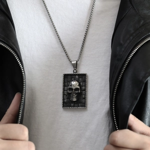 Détail d'un pendentif tête de mort vintage argenté sur une chaîne pour les styles punk