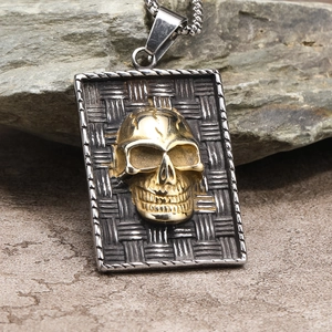 Détail du pendentif crâne vintage avec texture tressée et relief doré mat sur pierre