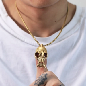 Close-up of golden stainless steel animal skull pendant necklace on a white t-shirt