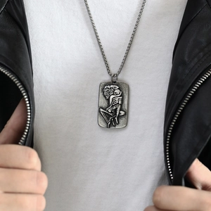 Detailansicht des Punk-Edelstahl-Anhängers mit Skelett-Relief an einem männlichen Model