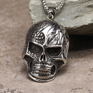 Vista detallada de colgante de calavera gótica con textura intrincada y acabado de acero envejecido