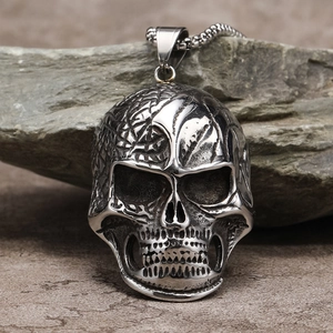 Primer plano del colgante de calavera gótica plateada con grabados 3D y cadena