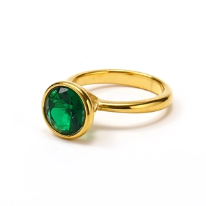 Detail of 18k gold plated ring with a bezel-set dark green faceted round gemstone