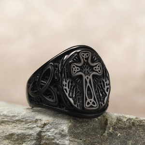 Vintage black titanium Celtic cross ring with knot engraving on a stone base