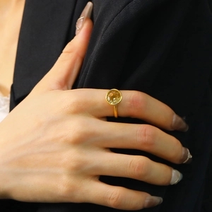 Close-up of yellow zircon ring in 18k gold finish worn on hand with black suit