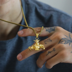 Dettaglio di un ciondolo a toro muscoloso dorato con catena a scatola quadrata stile hip-hop