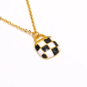 Gouden ketting met zwart-wit geruit emaille hanger aan een fijne schakelketting