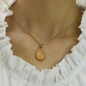 Elegante 18k vergulde roestvrijstalen schelp ketting op de nek van een vrouwelijk model