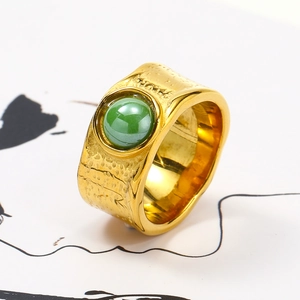 Macro detail of gold textured irregular ring featuring a green ceramic stone inlay