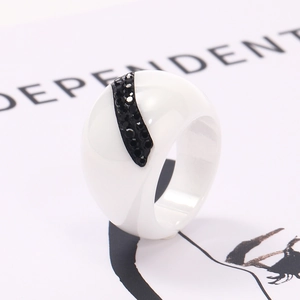 Macro shot of wide white ceramic ring with a black micro-pave diamond crescent inlay