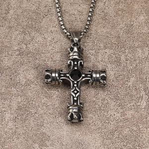 Macro shot of vintage cross pendant with black gem and detailed crown relief