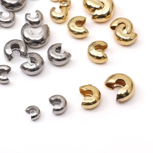 Detailed macro view of gold and silver stainless steel crimp cover beads for DIY jewelry