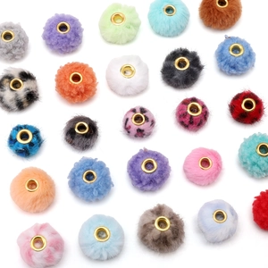 Dettaglio di perle in finta pelliccia colorata con occhielli dorati per gioielli DIY