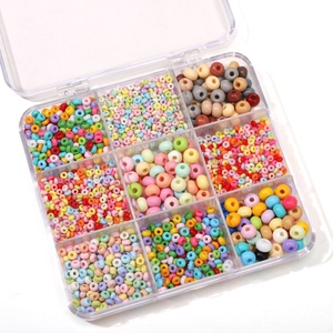 Macro shot of colorful glass seed beads set in a 10-grid transparent storage box for DIY crafts