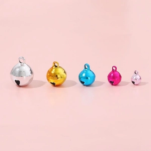 Set di cinque campanellini in metallo lucido in vari colori e dimensioni su rosa