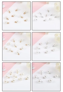 Vue détaillée de divers pendentifs en perles blanches avec boucles dorées et argentées