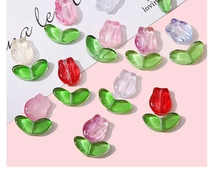 Macro shot of colorful glass tulip petals and green leaf beads for DIY jewelry making