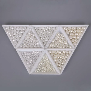 Detailed view of oval ABS faux pearls in white and cream shades on triangular trays