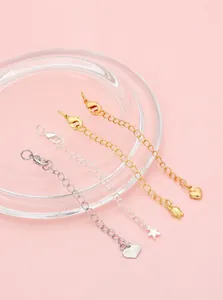 Detail of 14K gold and silver extender chains with heart, star, and tulip pendants