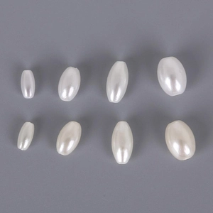 Macro shot of oval white ABS imitation pearls in multiple sizes for DIY jewelry making