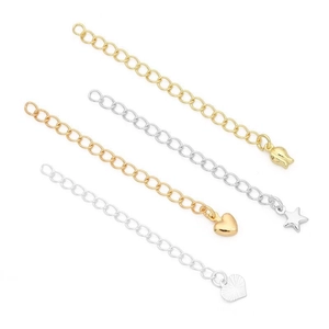 Detalle de cadenas de extensión de oro de 14K y plata con dijes de corazón y estrella