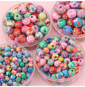 Vue détaillée de perles en pâte polymère de 6mm colorées avec motifs floraux en boîtes