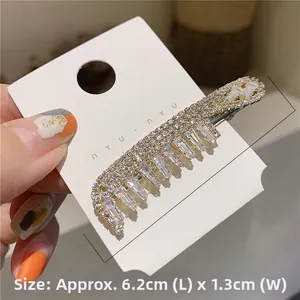 Detail view of 6.2cm gold hair clip with sparkling rhinestones on white card