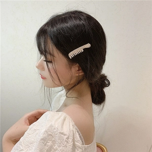 Elegant rhinestone comb-shaped hair clip worn by a model for a stylish side hairstyle