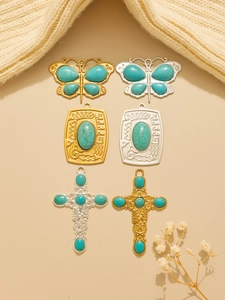 Detailed flat lay of bohemian turquoise cross and butterfly stainless steel charms