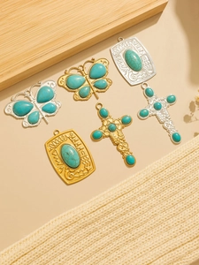 Detailed view of vintage Navajo style turquoise butterfly and cross charms set