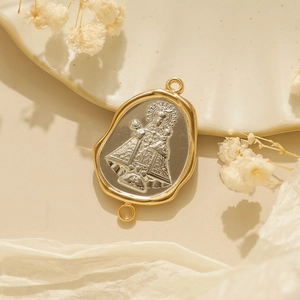 Dettaglio di un ciondolo religioso bicolore oro e argento con intaglio di un santo