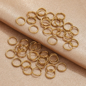 Polished gold plated stainless steel double jump rings on elegant champagne silk fabric