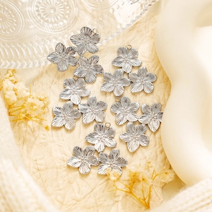 Detail of 304 stainless steel gold flower pendants with fine radial texture and hanging loops