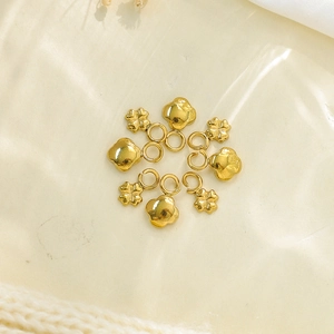 Macro shot of seven gold stainless steel four-leaf clover charms with jump rings for DIY jewelry