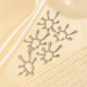 Close-up of five irregular hollow sun pendants on champagne silk and knit fabric