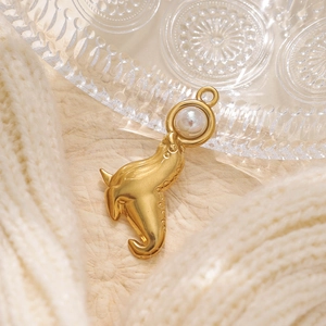 Macro dettagliata di un ciondolo a forma di delfino in oro opaco con perla di conchiglia