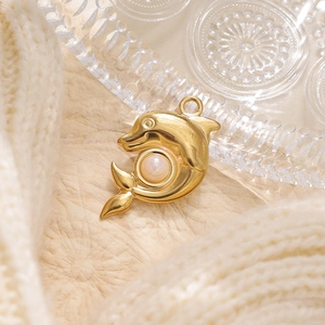Ciondolo delfino dorato con perla bianca su maglia calda e piatto di vetro decorativo