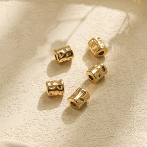 Macro shot of five golden 304 stainless steel beads with hammered texture for DIY jewelry