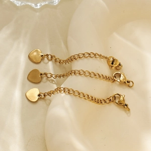 Trois chaînettes d'extension en acier doré 18 carats avec pendentifs cœur et fermoir homard
