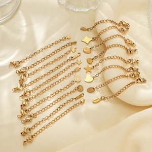 Détail de fermoirs mousquetons plaqués or 18k avec chaînes d'extension et pendentifs