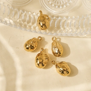 Macro view of gold lemon-shaped charms with textured finish for DIY jewelry