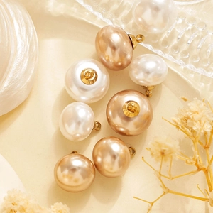 Detalle macro de colgantes de perlas bicolor con anillos de metal para joyería DIY