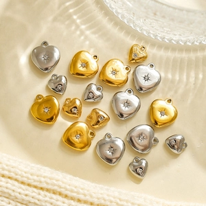 Colgantes de corazón con estrellas grabadas y cristales en acero dorado y plateado