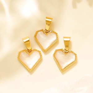 Detail of heart-shaped gold pendants with white pearl inlay and micro-bead edges
