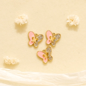 Detailopname van vlinderhangers met roze emaille en kristallen op gouden basis