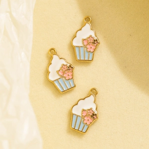 Three cupcake charms with blue base and pink flowers for DIY jewelry making